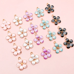 Macro view of colorful five-petal flower charms with golden metal base and enamel finish