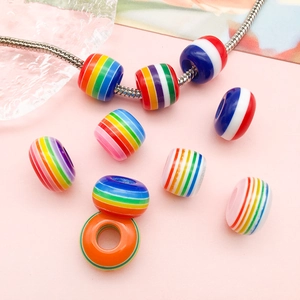 Makro-Detail von Regenbogenstreifen-Resinperlen an einer Schlangenkette für DIY-Schmuck