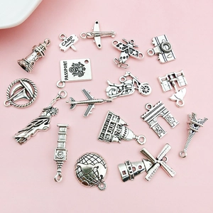 Detailoverzicht van antieke zilveren reis-thema metalen hangers op roze ondergrond