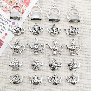 Vue macro de 20 breloques théières en argent vintage pour bijoux artisanaux