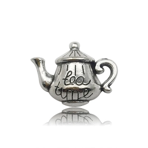 Macro d'une breloque théière vintage avec gravure Tea Time et finition antique