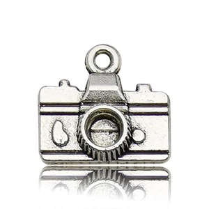 Macro-detail van antiek zilveren camera-hanger met lenstextuur en oogje voor sieraden