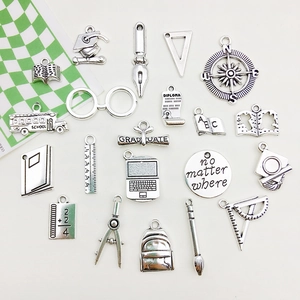 Detailed view of silver alloy graduation charms including school bus and diploma