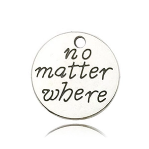 Macro shot of silver metal alloy pendant with 'no matter where' engraved lettering