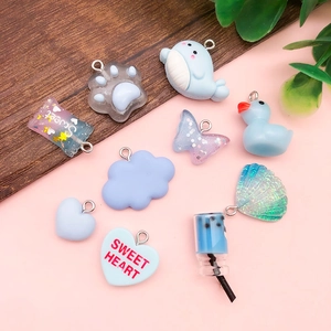 Flat lay of blue resin charms showing shapes of clouds, hearts, and small whales