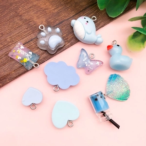 Close-up of cute blue resin charms including dolphin and candy shapes with metal rings