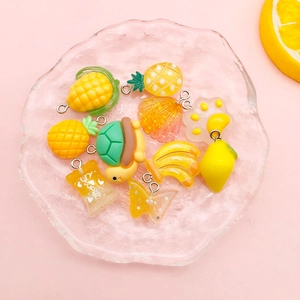 Makro-Detail von gelben Harzanhängern für DIY-Schmuck in einer Glasschale mit Wellenrand