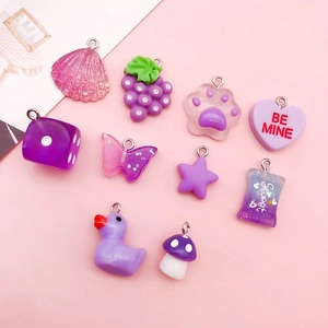 Macro shot of 10 purple resin charms including shells, cat paws, and stars for DIY crafts