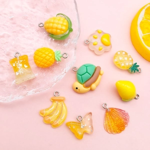 Makroaufnahme gelber Harzanhänger wie Ananas und Mais für DIY-Schmuckherstellung
