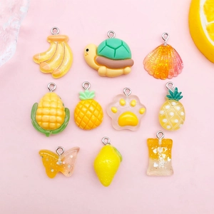 Flachbild von bunten Harzanhängern wie Banane, Muschel und Schmetterling für DIY Schmuck