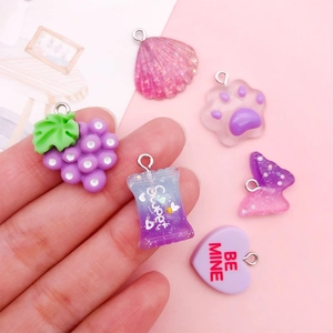 Detailed view of purple resin charms including grape, cat paw and shells for DIY jewelry
