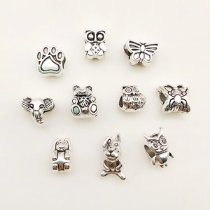 Detailed view of ten antique silver DIY animal charms including owls, cats and bears