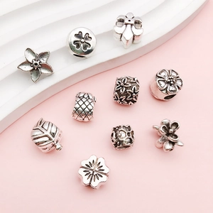 Detailed view of vintage silver alloy large hole beads with floral and heart patterns