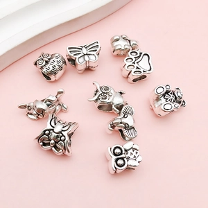 Detail of antique silver DIY beads featuring owl, butterfly, and animal charms