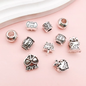 Macro shot of silver vintage alloy beads with Love Bravely and Peace engravings