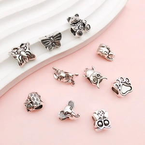 Detailed view of vintage silver animal charms including owls and butterflies for DIY bracelets