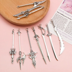 Pendentifs vintage en alliage d'argent avec épées et lances sur un fond rose doux