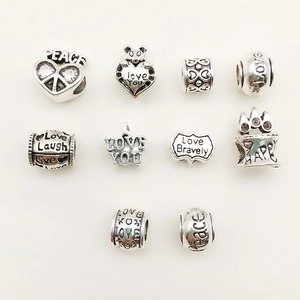 Macro shot of assorted silver alloy beads including hearts and crowns for DIY bracelets
