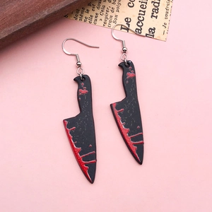 Détail de boucles d'oreilles couteau de cuisine en acrylique gothique avec taches de sang