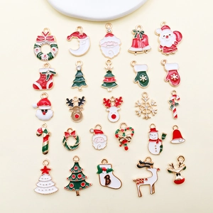 Flat lay of 25 colorful Christmas enamel charms with Santa, tree, and reindeer designs