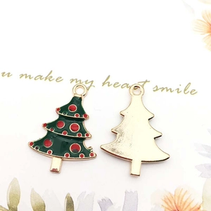 Detail of Christmas tree charms with green enamel finish and golden metal backing