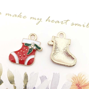 Detailed view of red Christmas sock charm with white rhinestones and golden base detail