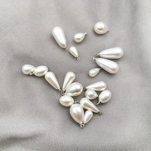 Detailansicht verschiedener Tropfenperlen mit silbernen Metallkappen für DIY-Schmuck