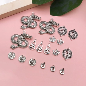 Detailed view of vintage silver alloy dragon pendants and traditional Chinese charms