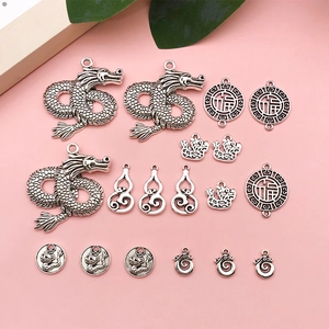 Detailed view of vintage silver dragon charms and fortune pendants for DIY jewelry design