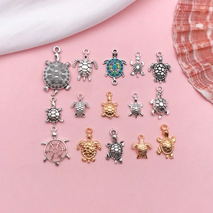 Detailed overhead shot of assorted turtle pendants in antique silver and gold finishes