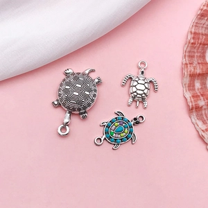 Three vintage silver turtle jewelry charms with blue green and purple drip oil detailing