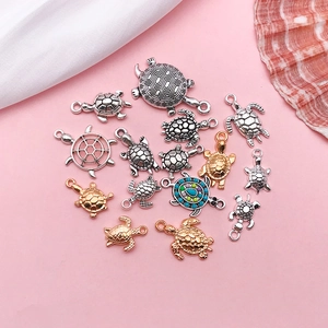 Macro view of assorted turtle charms in antique silver and gold for DIY jewelry making