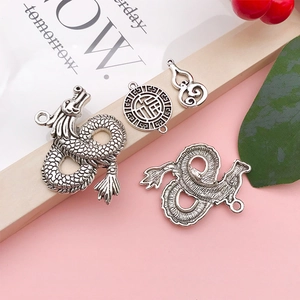 Detailed close-up of antique silver dragon and Fu character pendants with vintage texture