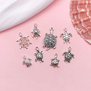 Detailed view of eight vintage silver turtle alloy pendants for DIY jewelry making sets