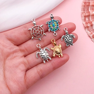 Assorted turtle jewelry pendants in antique silver and gold finishes for DIY crafting