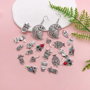 Macro shot of owl-themed alloy pendants and earrings for DIY handmade jewelry crafts