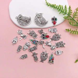 Flat lay of retro alloy owl pendants and charms for DIY jewelry making and craft projects