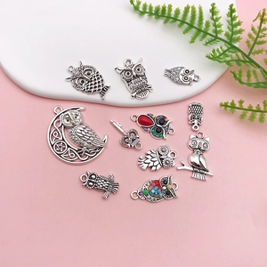 Detailed macro view of vintage silver owl pendants for DIY jewelry and crafts
