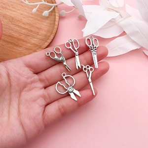 Makroaufnahme von fünf Mini-Scherenanhängern im Vintage-Silberstil für DIY-Schmuck