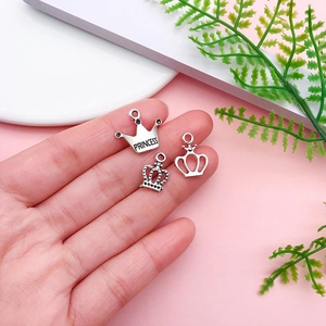 Detailed close-up of three antique silver crown charms for DIY jewelry making
