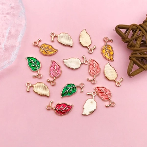 Detailansicht der bunten Emaille-Blattanhänger mit Goldmetallkanten für DIY-Schmuck
