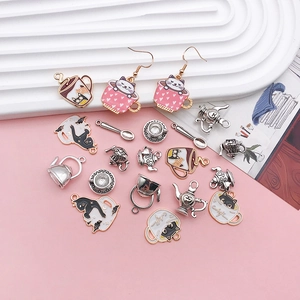 Detail of cute cat teacup charms and pink enamel heart earrings for DIY jewelry making