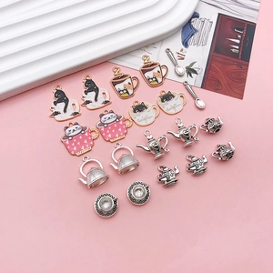 Macro detail of alloy cat teacup pendants and metal teapot charms for DIY jewelry