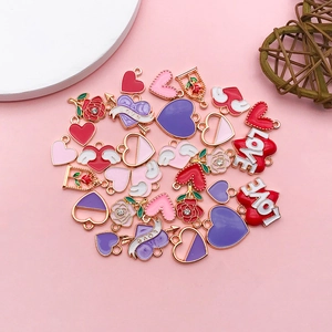 Close-up of heart and rose enamel alloy charms for DIY jewelry making in multiple colors