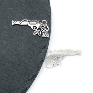 Detailed view of vintage silver alloy revolver pendant with floral rose carvings