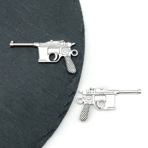 Macro detail of Mauser C96 pistol shaped alloy pendants in vintage silver finish