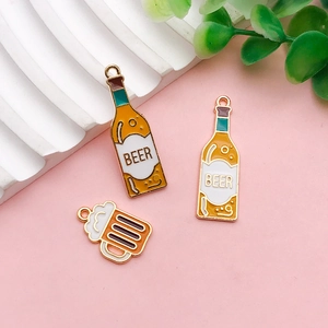 Close-up of DIY acrylic beer bottle and mug pendants with gold alloy loops for jewelry