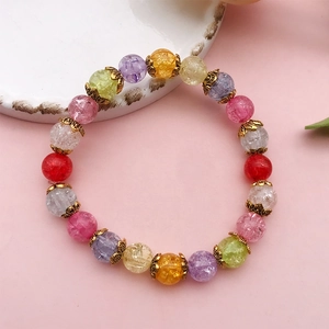 Détail d'un bracelet en perles de verre craquelé avec coupelles à fleurs en métal doré antique