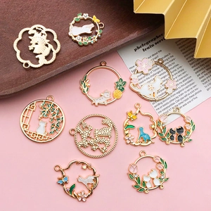 Detailed view of DIY cat and cherry blossom charms with gold plating and enamel inlay