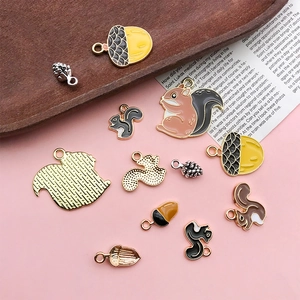 Detailed close-up of squirrel and pinecone alloy enamel charms for DIY jewelry making